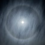 photo of moon in a rings of mist and clouds